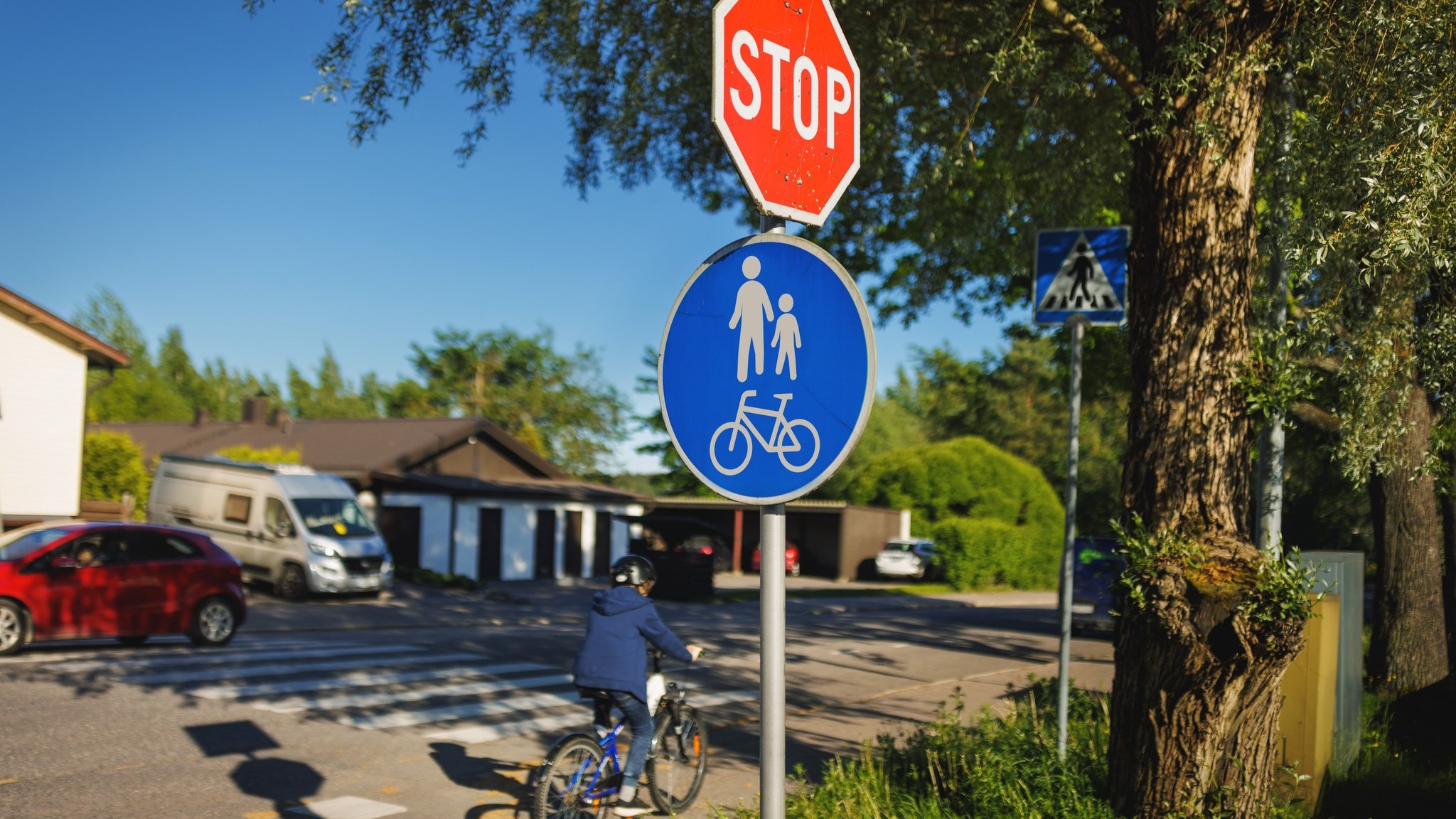 Ett barn cyklar med trafikmärken i bakgrunden. (Bild: Parkus Pentikäinen, Keksi / LVM)