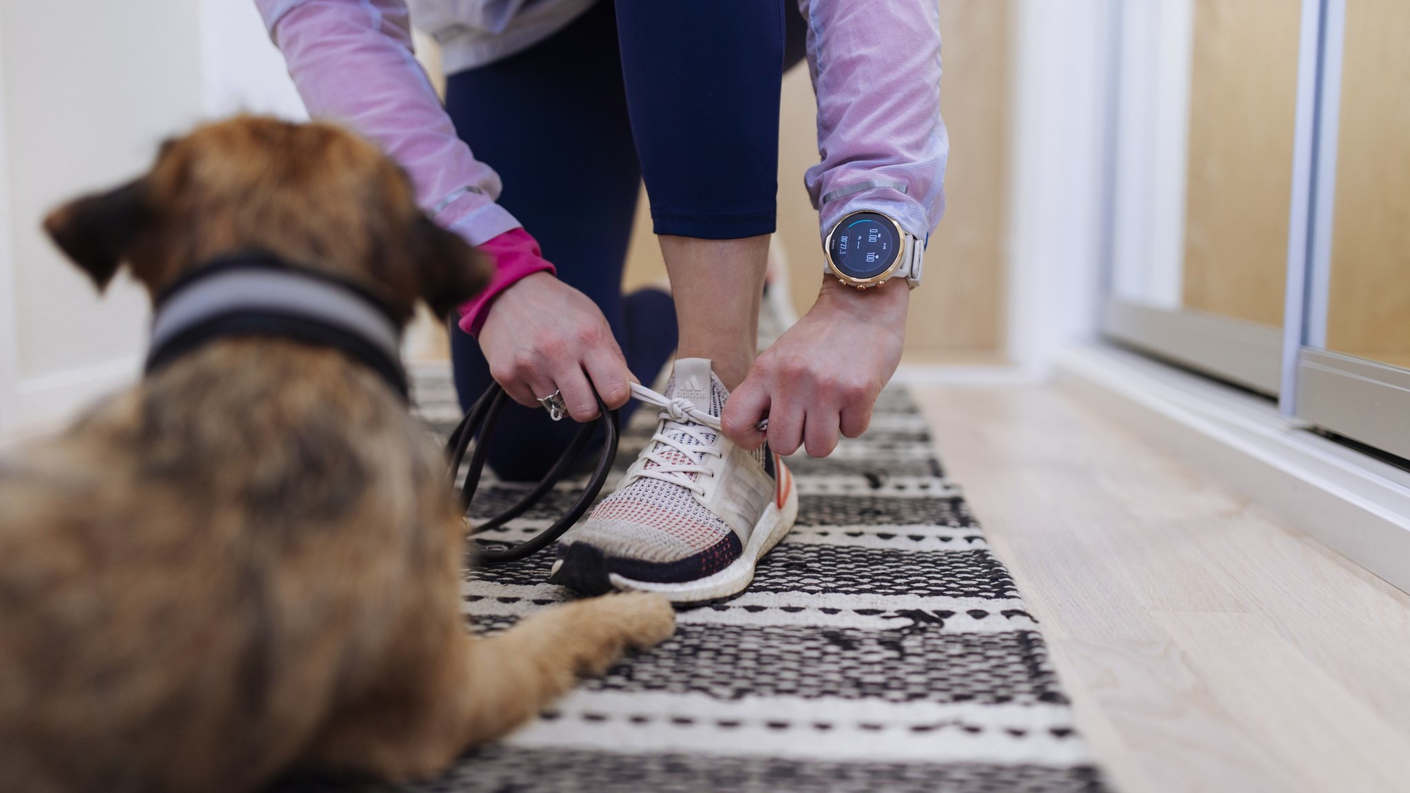 Nainen solmii kengännauhoja älykello kädessä. (Kuva: Mika Pakarinen, Keksi)