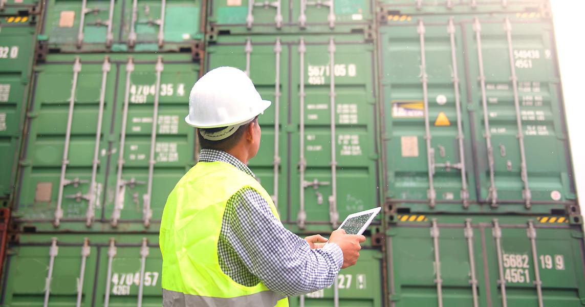 Satamatyöntekijä tarkastaa kontteja sähköisesti. (Kuva: Shutterstock)