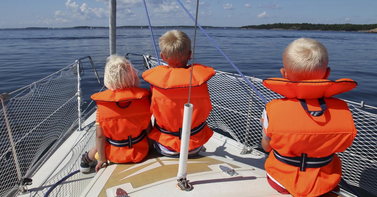 Lapsia pelastusliiveissä purjeveneen keulassa (Kuva: Shutterstock)