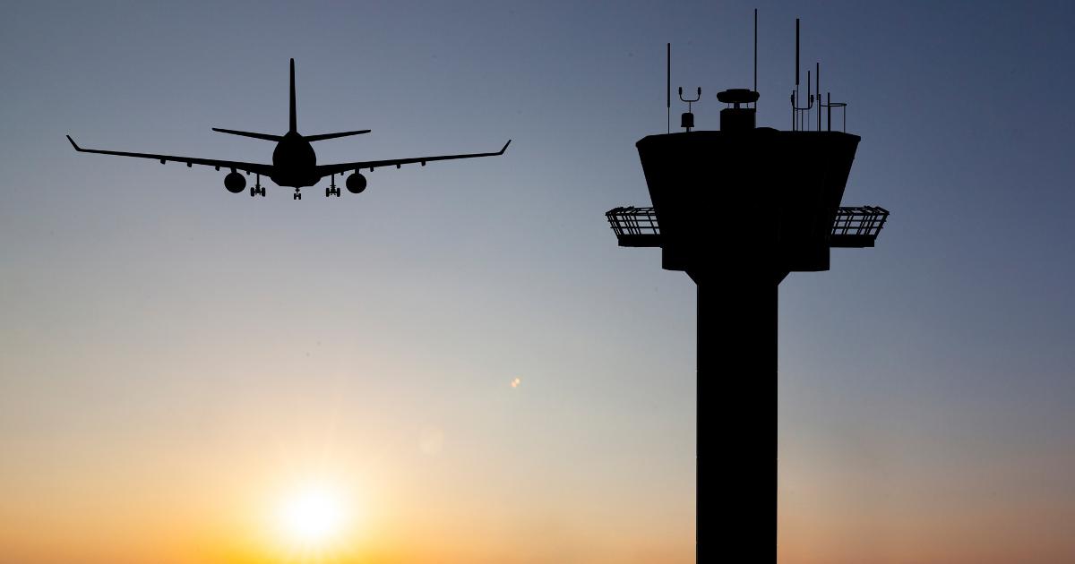 Aeroplane in air and control tower in the evening (Photo: Shutterstock)
