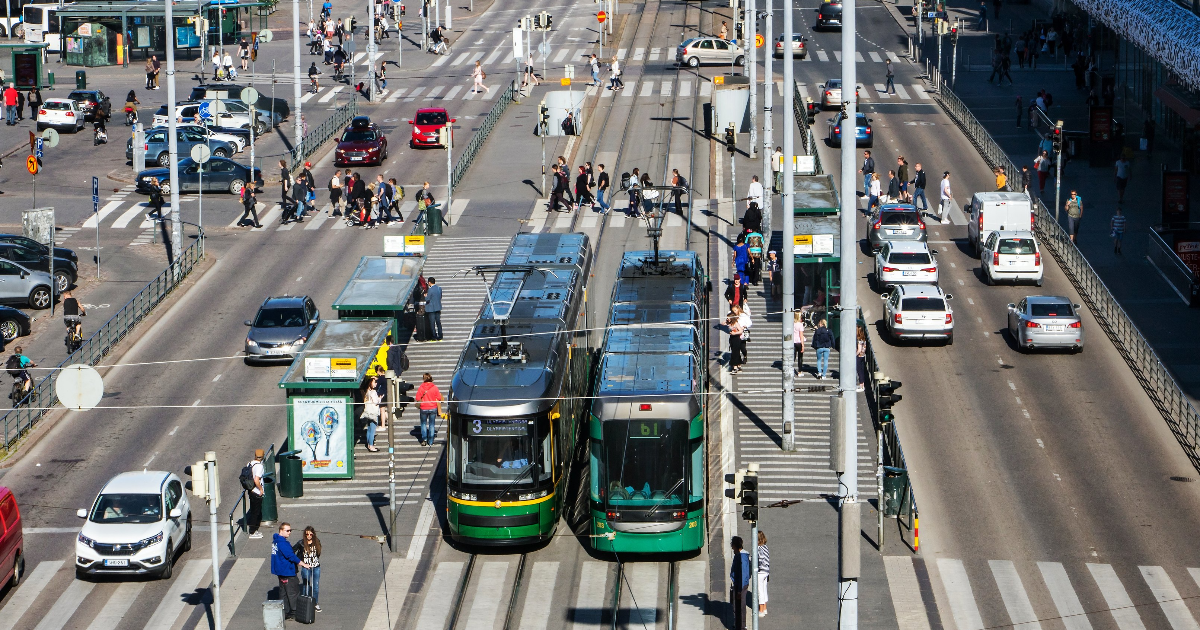 Raitiovaunuja ja autoja Helsingissä rautatieaseman edessä (Kuva: Shutterstock/Milkovasa)