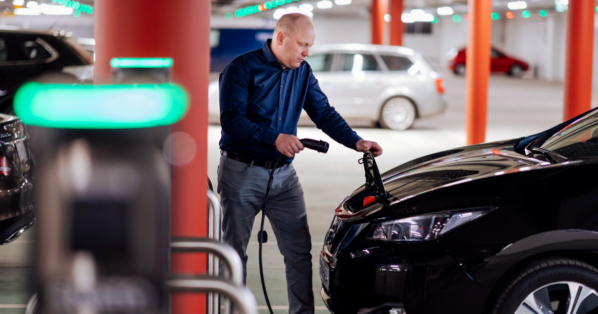 Autoilija lataa sähköautoa parkkihallissa. (Kuva: Mika Pakarinen, Keksi / LVM)
