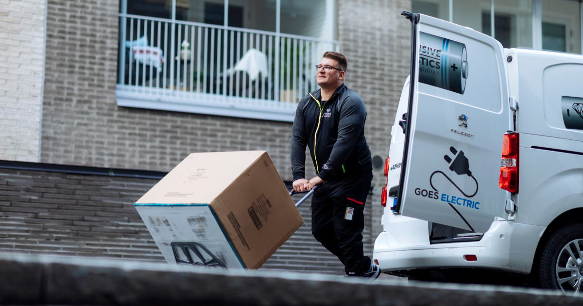Mies kuljettaa pakettia kärryillä sähkökäyttöisestä pakettiautosta. (Mika Pakarinen, Keksi/LVM)