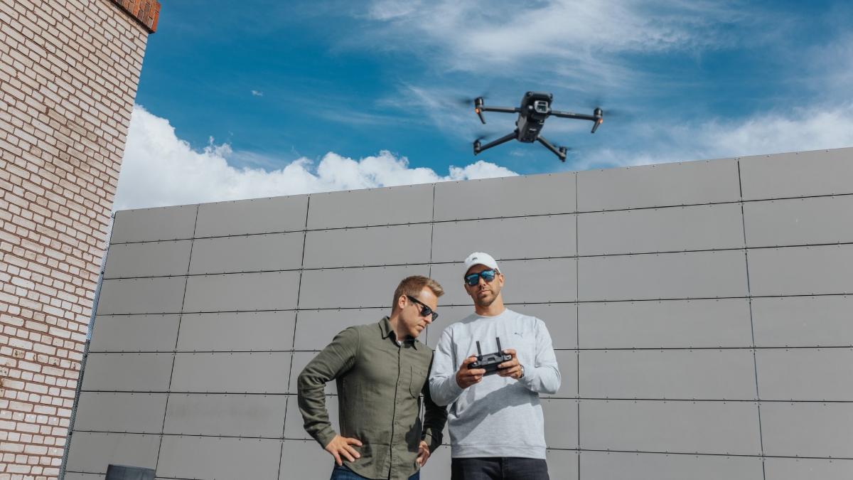 Kaksi ihmistä lennättää dronea