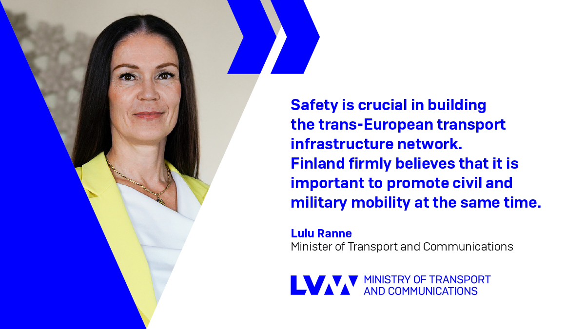 Liikenne- ja viestintäministeri Lulu Ranne keltaisessa bleiserissä ja sitaatti: On erittäin tärkeää, että koko Euroopan laajuista väyläverkkoa rakennetaan turvallisuus huomioon ottaen. Suomelle on tärkeää, että siviili- ja sotilasliikkuvuutta edistetään samanaikaisesti.
