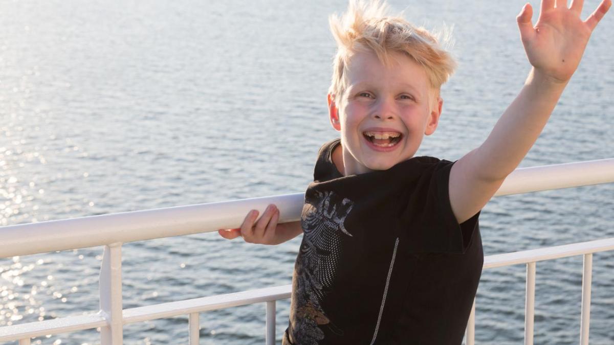 A boy waving on a ship deck (Photo: Rodeo, Juha Tuomi)