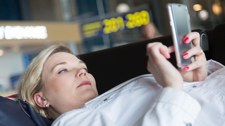 Nainen käyttää älypuhelinta julkisessa tilassa (Kuva: Rodeo, Juha Tuomi)