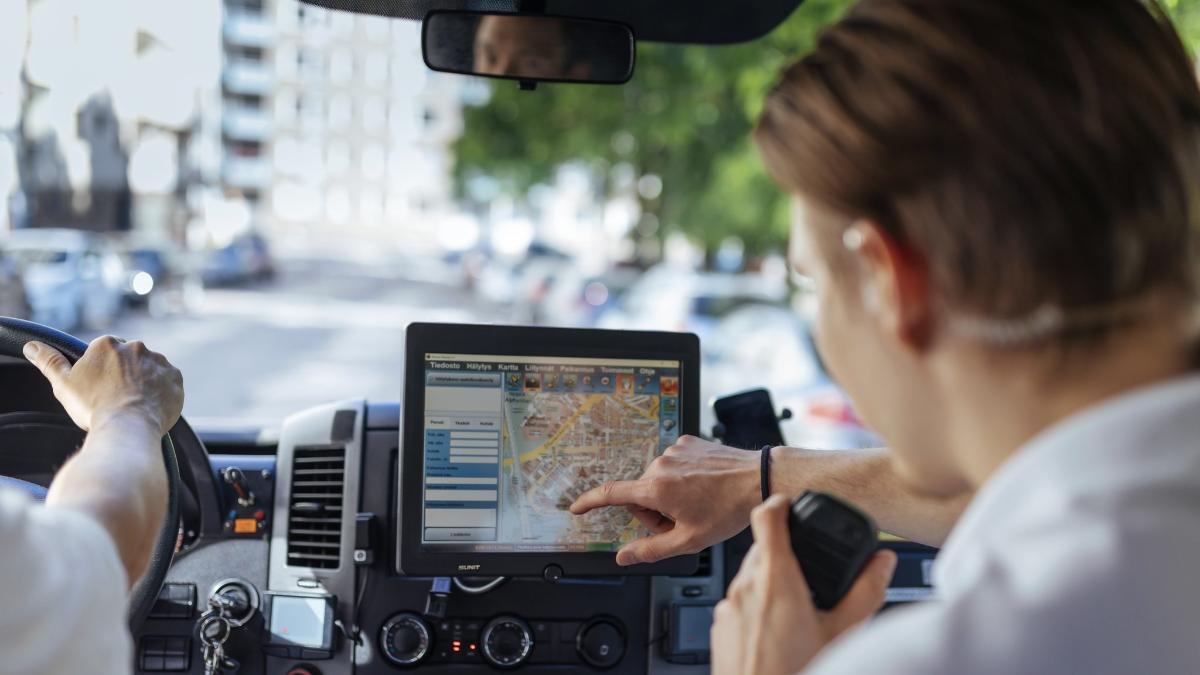 Ensihoitaja katsoo auton navigaattorin karttanäyttöä