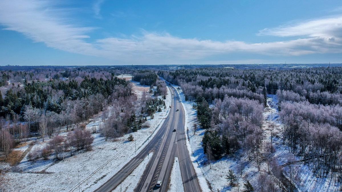 Talvinen ilmakuva, jossa näkyy liittymä ja lumista metsää