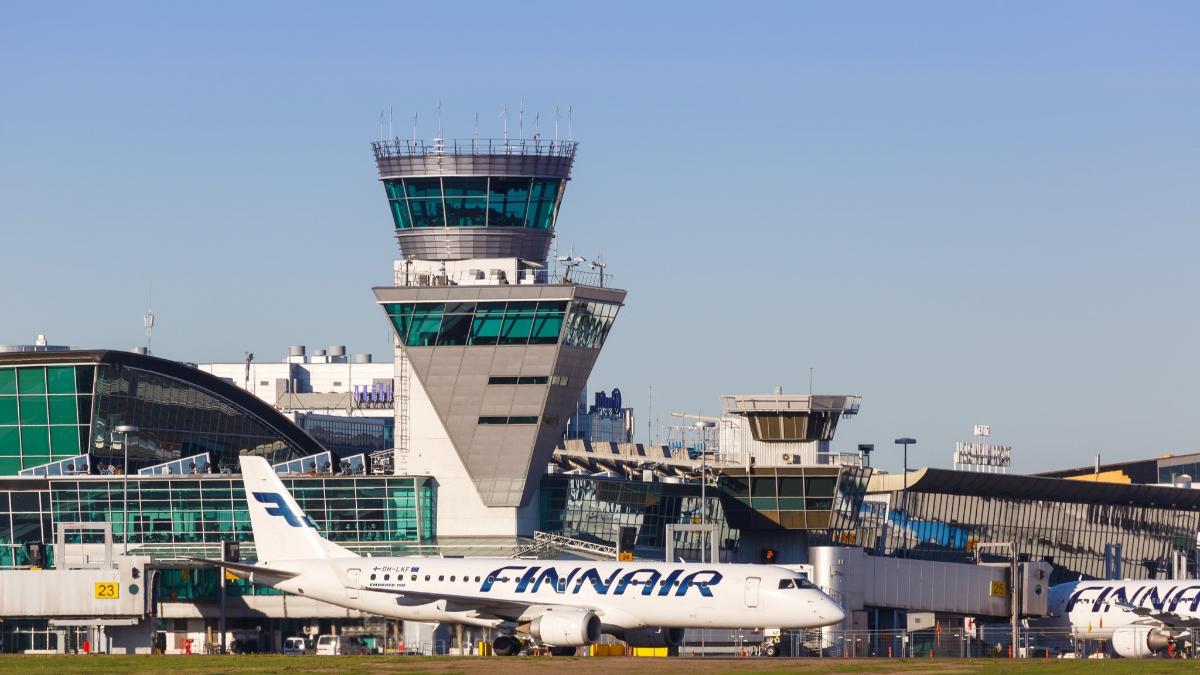 Finnairin lentokone kentällä, taustalla lentokentän rakennuksia