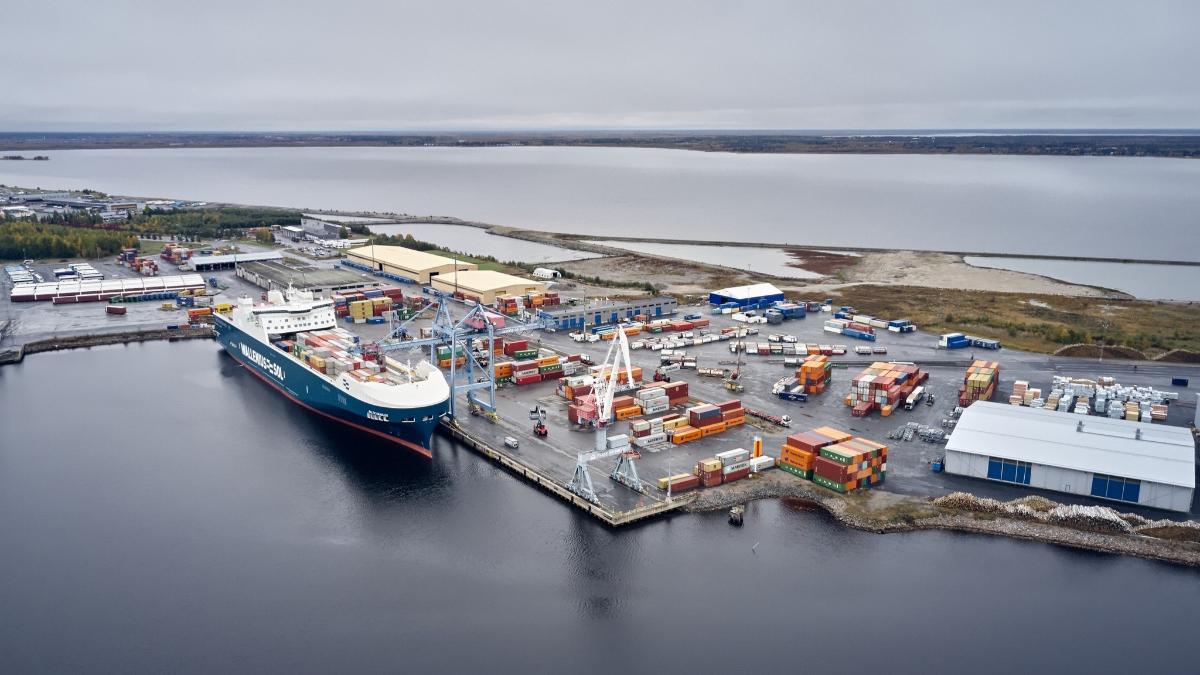 Ilmakuvassa näkyy rahtialus ja useita kontteja Oulun satamassa.