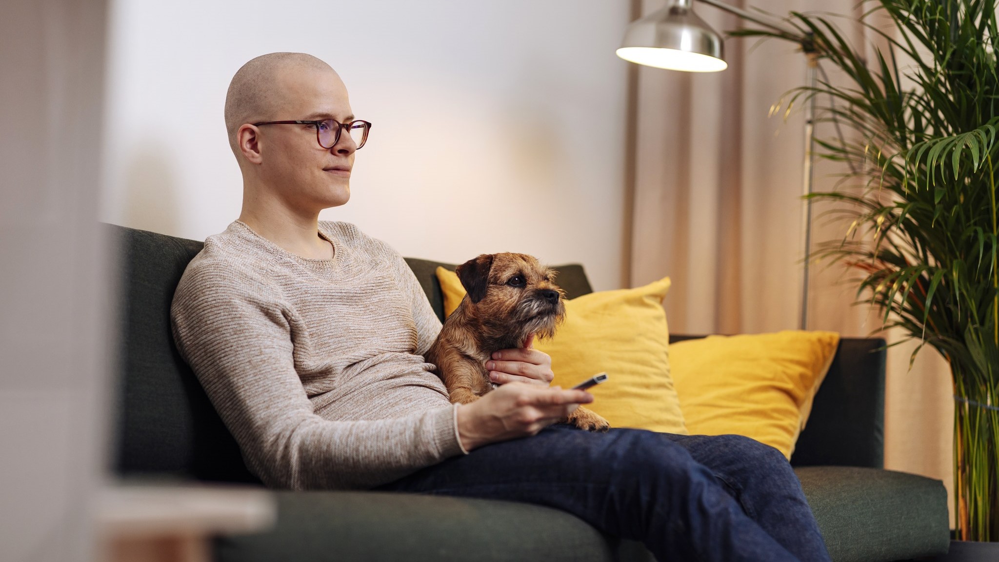 Mies katsoo televisiota sohvalla koiran kanssa (Kuva: Mika Pakarinen, Keksi/LVM)